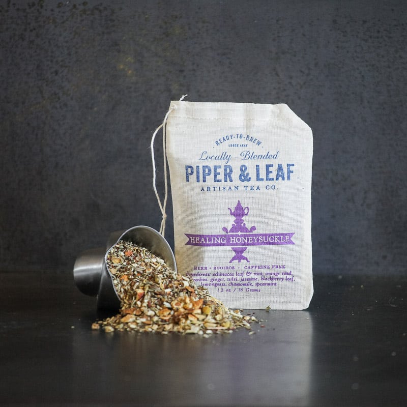 Piper and Leaf Healing Honeysuckle Muslin Bag of Loose Leaf Tea - 15 Servings in a cup, displayed in a natural setting.