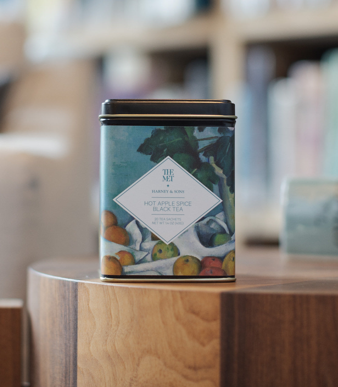Harney & Sons Hot Apple Spice Black Tea, Tin of 20 sachets, displayed in a cozy setting with warm colors and tea accessories.