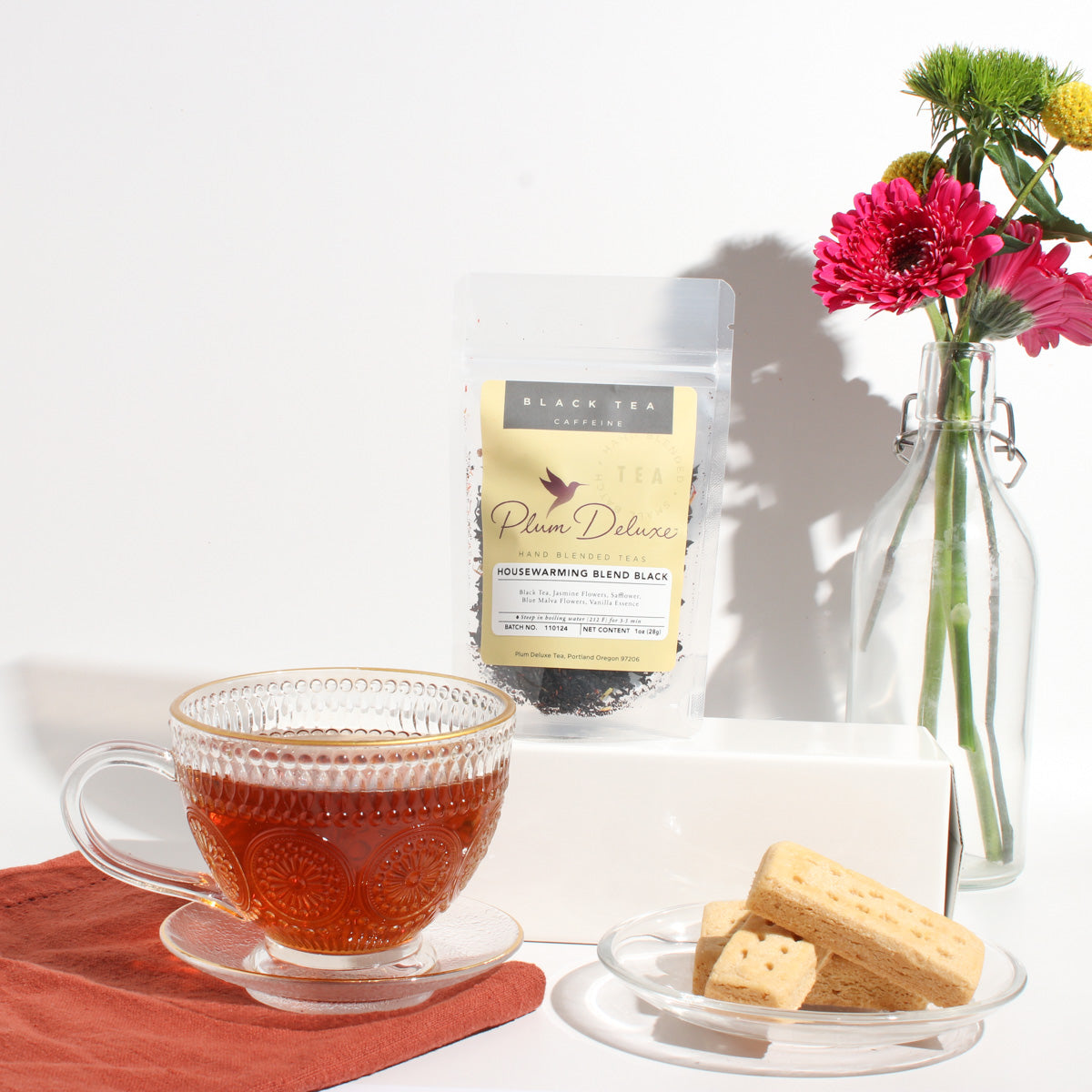 Plum Deluxe Housewarming Blend Black Tea (Vanilla Creme Brulee) in a lifestyle setting, featuring a teacup and loose tea.