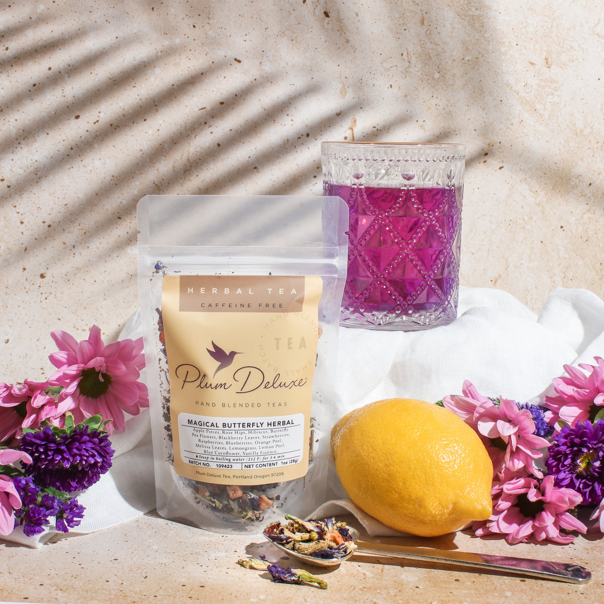 Image of Plum Deluxe Magical Butterfly Herbal Tea featuring butterfly pea flowers and berries in a lifestyle setting.