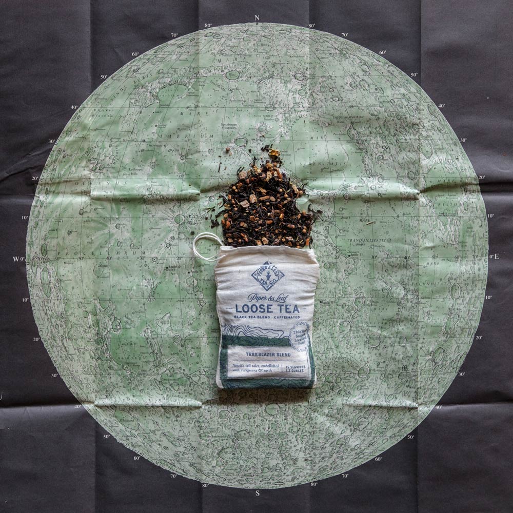Piper and Leaf Trailblazer Blend Muslin Bag of Loose Leaf Tea - 15 Servings displayed in a photo with a travel theme.