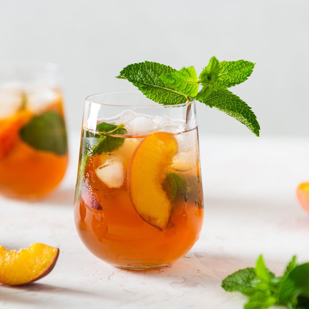 Tea with Tae Peach & Apricot Iced Tea Tin Gift (8 pillow bags) showing a colorful tin with peach and apricot-themed design.