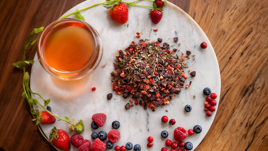 a glass cup of amber-colored berry tea on a white marble plate, with a pile of loose berry tea blend