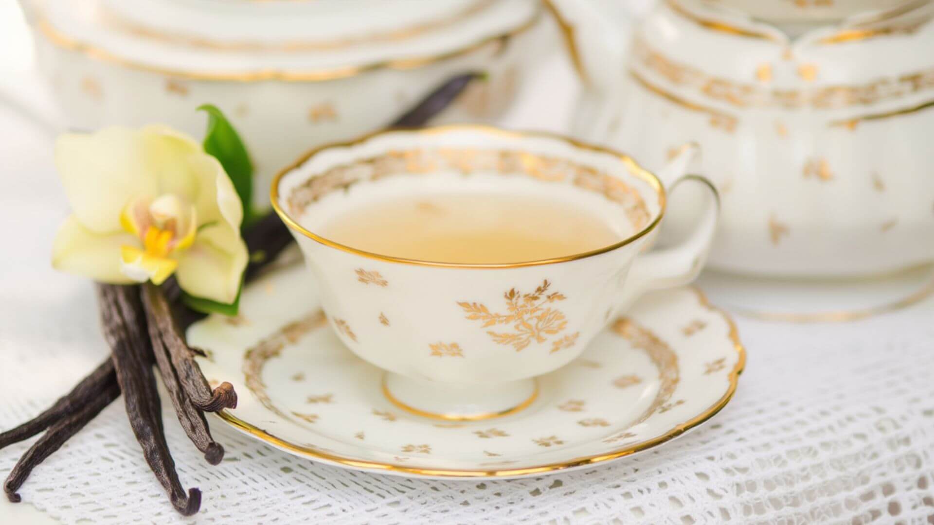 Vanilla tea in a teacup with vanilla orchid flower on the side