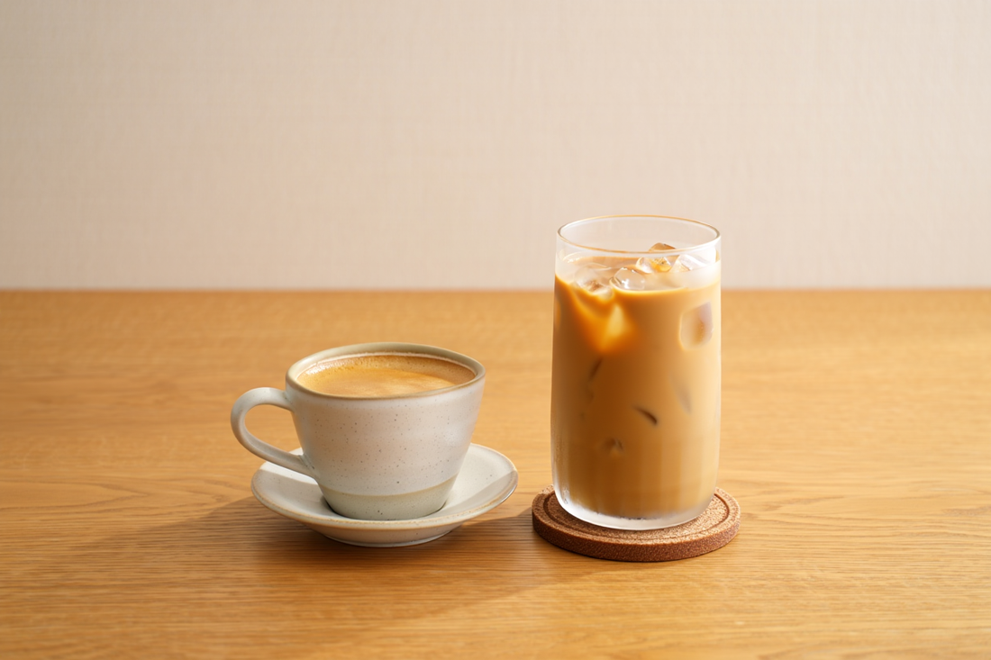 Hot hojicha latte in a ceramic cup next to an iced hojicha latte in a tall glass