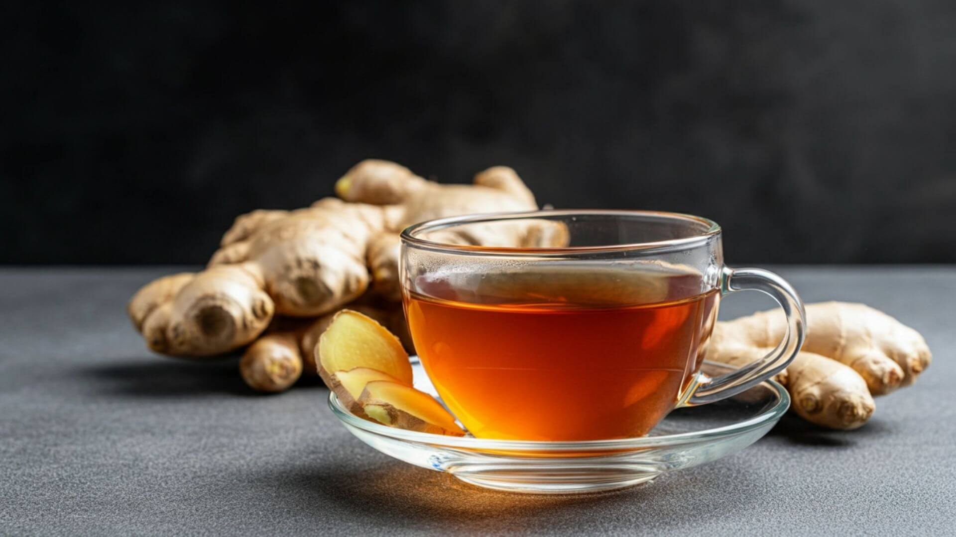 Ginger tea in a glass with ginger in the background