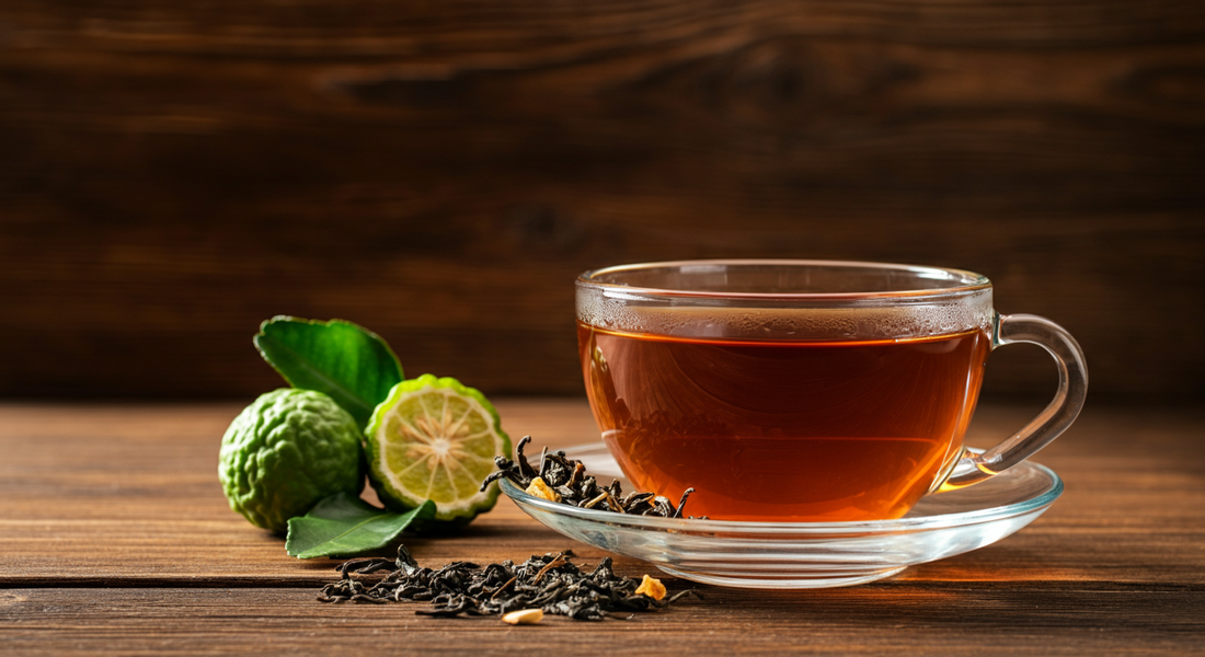 Glass teacup of amber Earl Grey tea with bergamot and leaves, softly lit for a warm feel and distinctive Earl Grey tea taste.