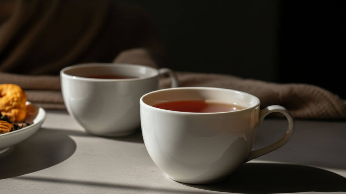 A cozy tea setup featuring a white ceramic teacup filled with english breakfast tea