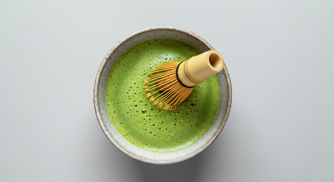Traditional bamboo matcha whisk (chasen) on a cup of matcha.