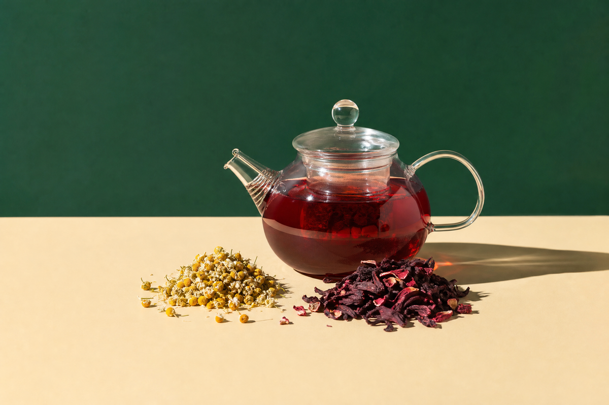 A round clear glass teapot filled with ruby-red hibiscus infusion