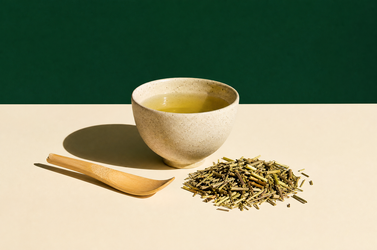 A speckled beige ceramic cup of pale golden-green twig tea