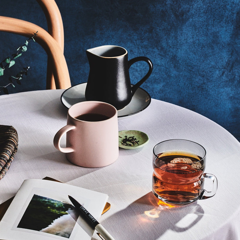 Lavender Earl Grey tea set on a table with a pink mug, and a black teapot