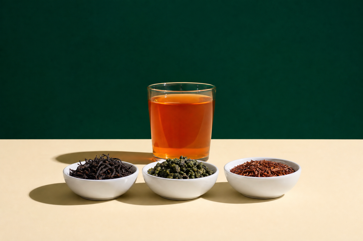 Three small plain white ceramic bowls in a neat straight row holding dark twisted black tea leaves