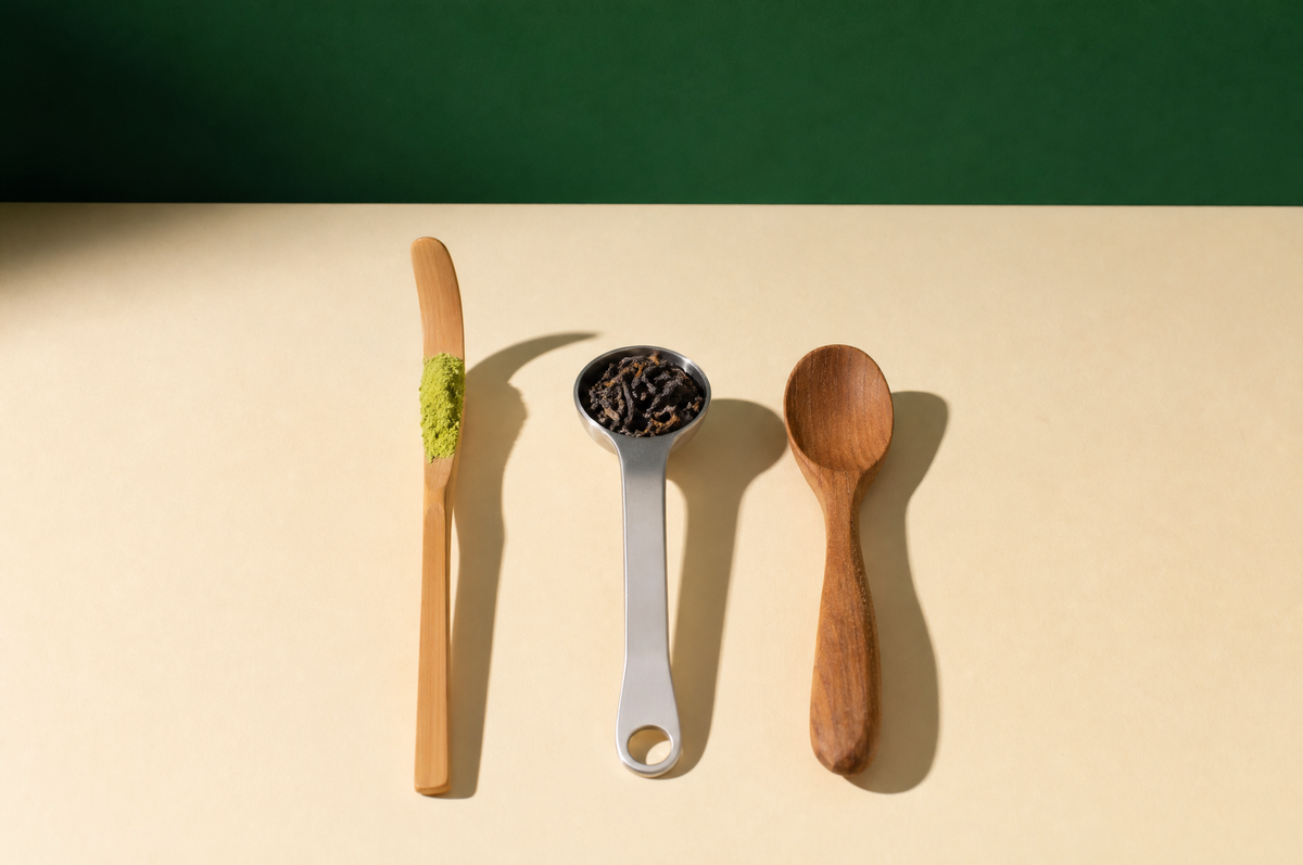 Three tea spoons lying flat on the cream surface in a neat parallel row
