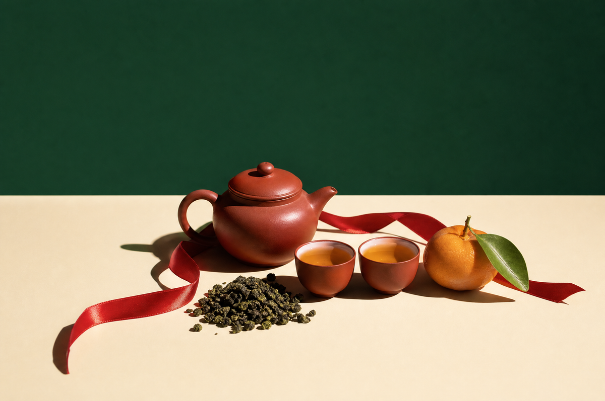 Lunar New Year tea: clay teapot, oolong leaves, red ribbon and a mandarin