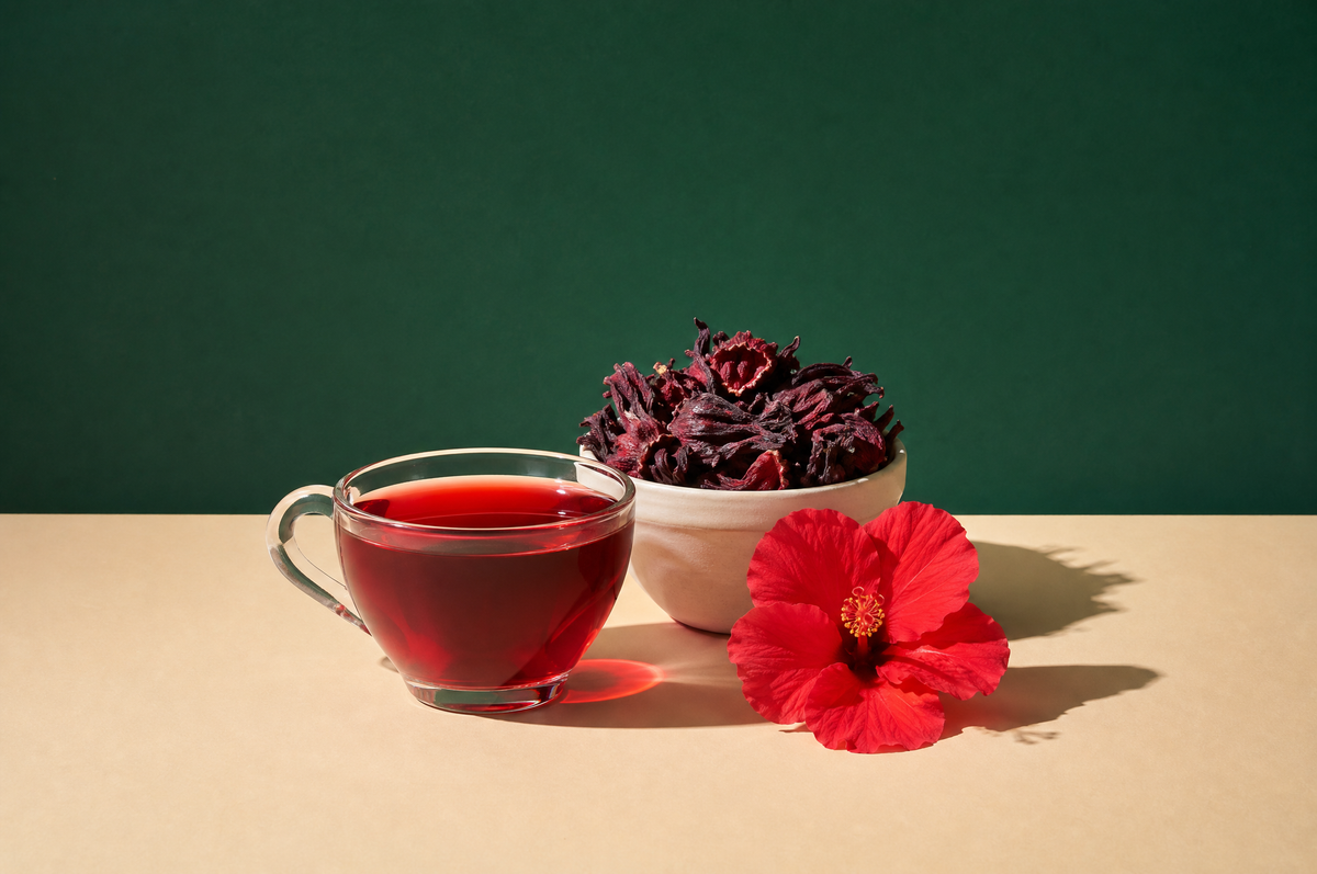 A clear glass teacup of deep ruby-red hibiscus tea