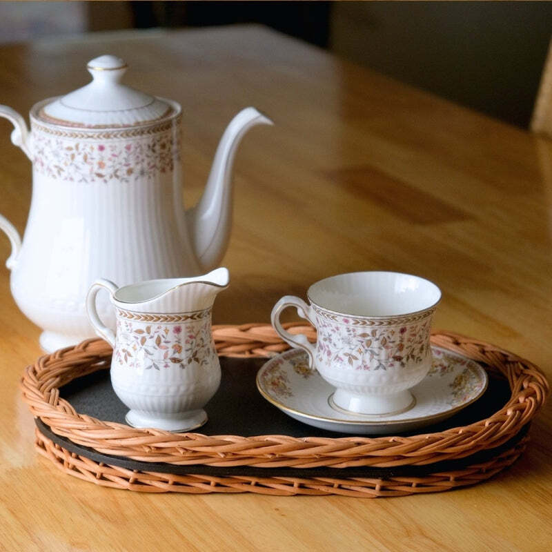 White porcelain tea cups on a black tea tray