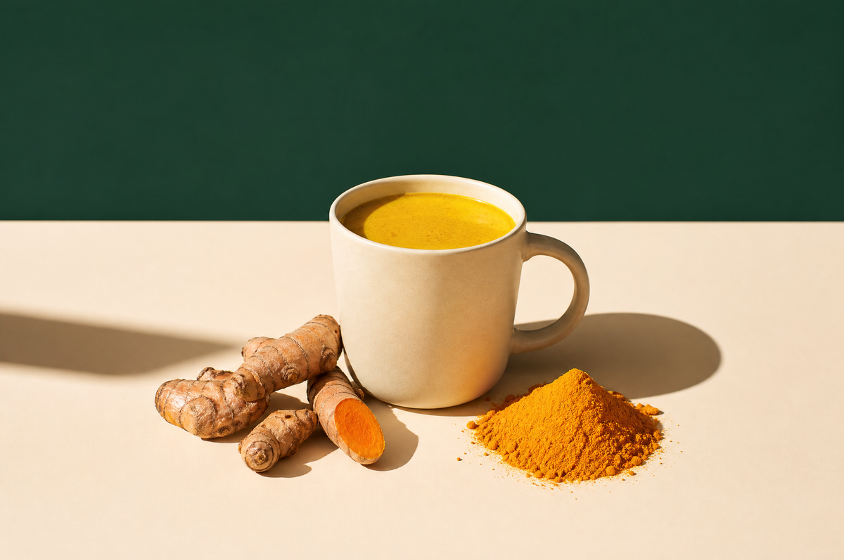 A matte cream stoneware mug of creamy golden turmeric milk tea