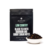 August Low Country - Bourbon Sugar Black Tea in a cup, showcasing a warm beverage with rich color and aromatic steam.