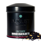 August Low Country - Bourbon Sugar Black Tea in a tin with tea leaves displayed alongside