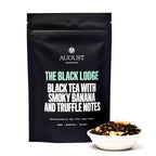 August The Black Lodge - Smoky Banana Black Tea in a 15-cup bag, featuring a black and yellow design.