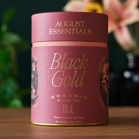 August Essentials Black Gold Black Tea - 15 Tea Bags, featuring organic Yunnan black tea with caramel and shortbread notes.