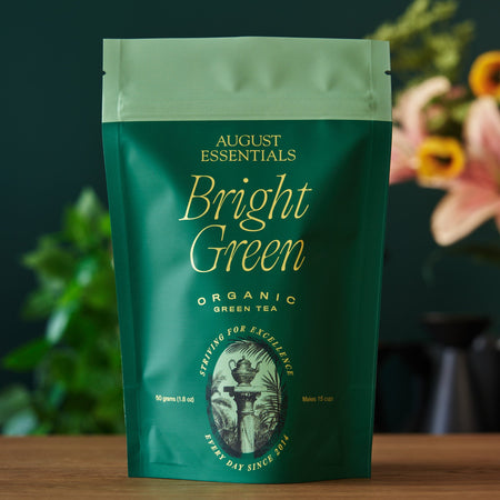 Bright Green Green Tea by August, featuring organic kukicha leaves in a bag, showcasing a refreshing lemon and honeysuckle flavor.