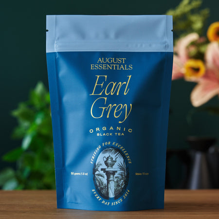 August Essentials Earl Grey Black Tea in a cup, featuring organic black tea, bergamot essence, and cornflower petals.