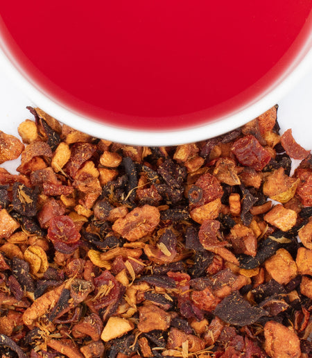 Harney & Sons Blood Orange Fruit Tea in a cup, showcasing vibrant orange color and dried fruit infusion. Caffeine-free beverage.