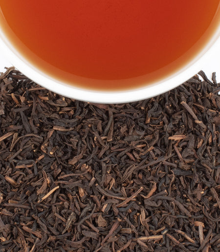 Harney & Sons Decaf Peaches & Ginger tea blend with peach and ginger pieces in a cup, showcasing a soothing beverage option.
