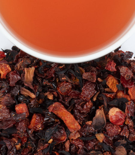 Harney & Sons Peach Fruit Tea in a cup, featuring a vibrant ruby red infusion with peach, rosehips, and hibiscus.