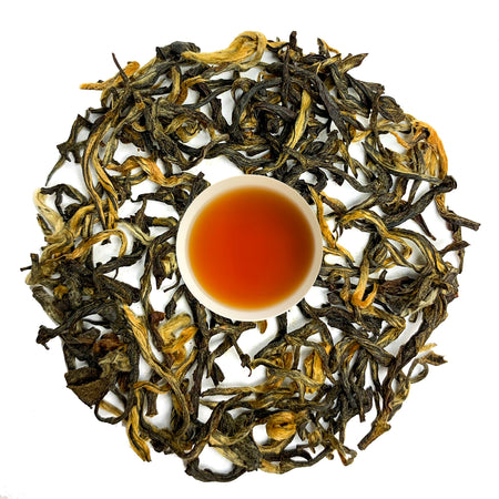 Danfe Shangri-La Golden Tips Tea, black loose-leaf tea with golden tips, showcasing brewed tea leaves and liquor in a cup.