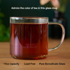 August Glass Mug - Clear Elegance by August, a 14-ounce heat-resistant borosilicate glass mug showcasing vibrant tea hues.
