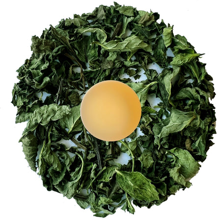 Danfe Himalayan Spearmint Tea (Caffeine-Free) in a circular presentation with a cup of brewed tea and fresh spearmint leaves.