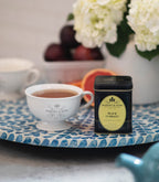 Harney & Sons Black Currant Tea in a tea setting with a teacup and tea leaves, from vendor Harney & Sons.