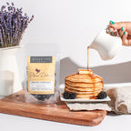 Plum Deluxe Breakfast in Bed Black Tea (Blackberry - Hazelnut) in a cozy lifestyle setting with tea cup and snacks.