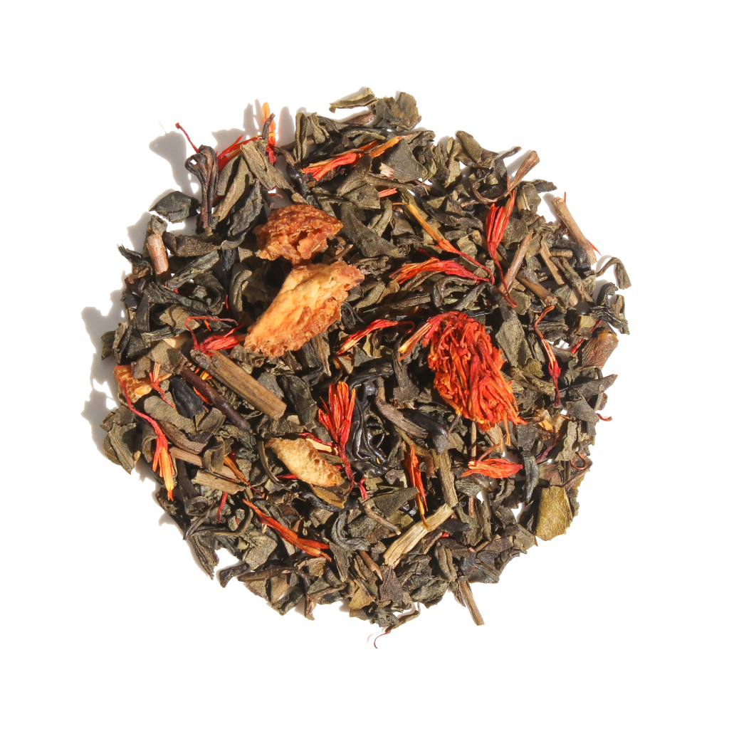 Plum Deluxe Candied Orange Green Tea in a circular tin, featuring a blend of green tea and candied orange notes.