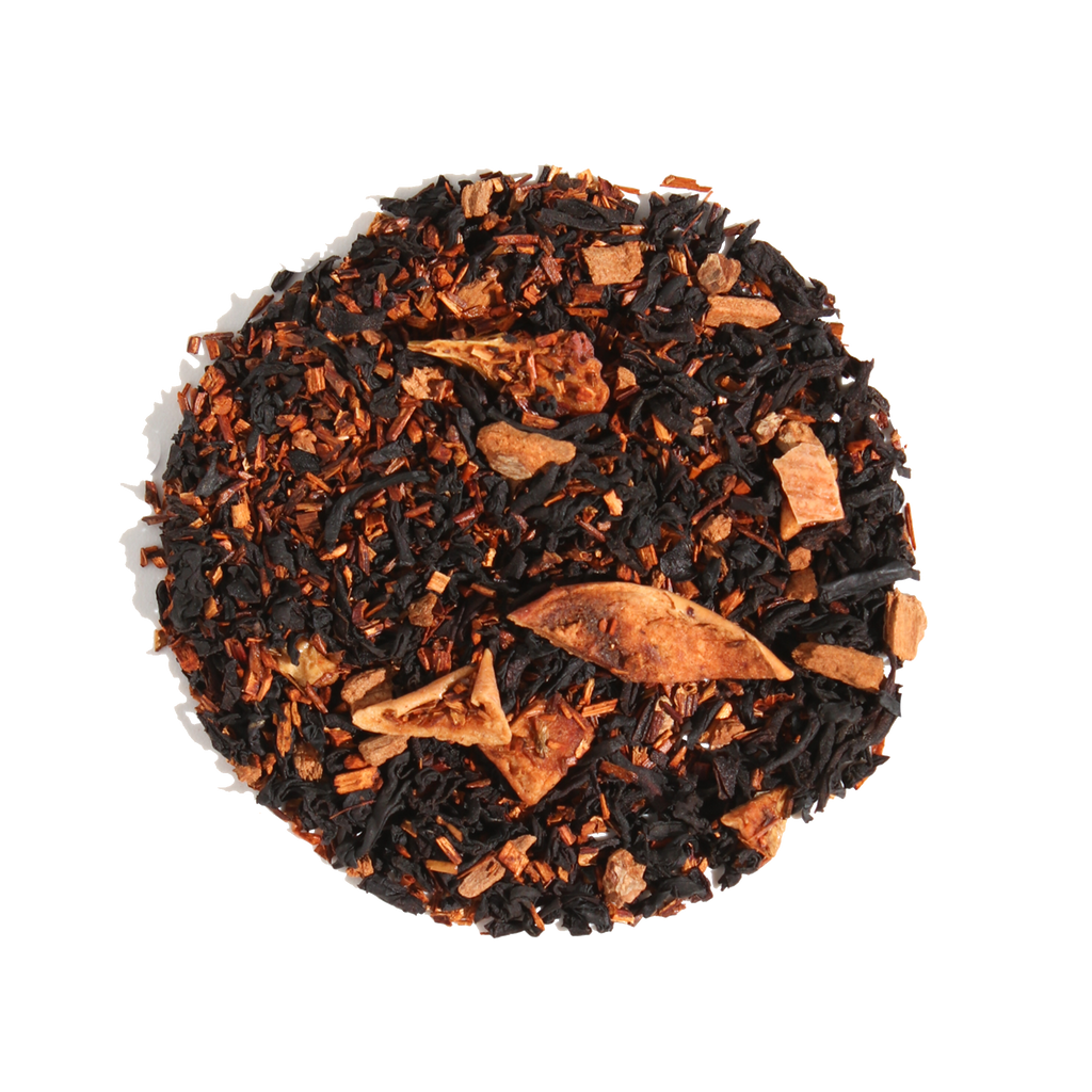 Plum Deluxe Caramel Almond Black Tea in a circular packaging, showcasing its blend of black tea, apple, cinnamon, and almond.
