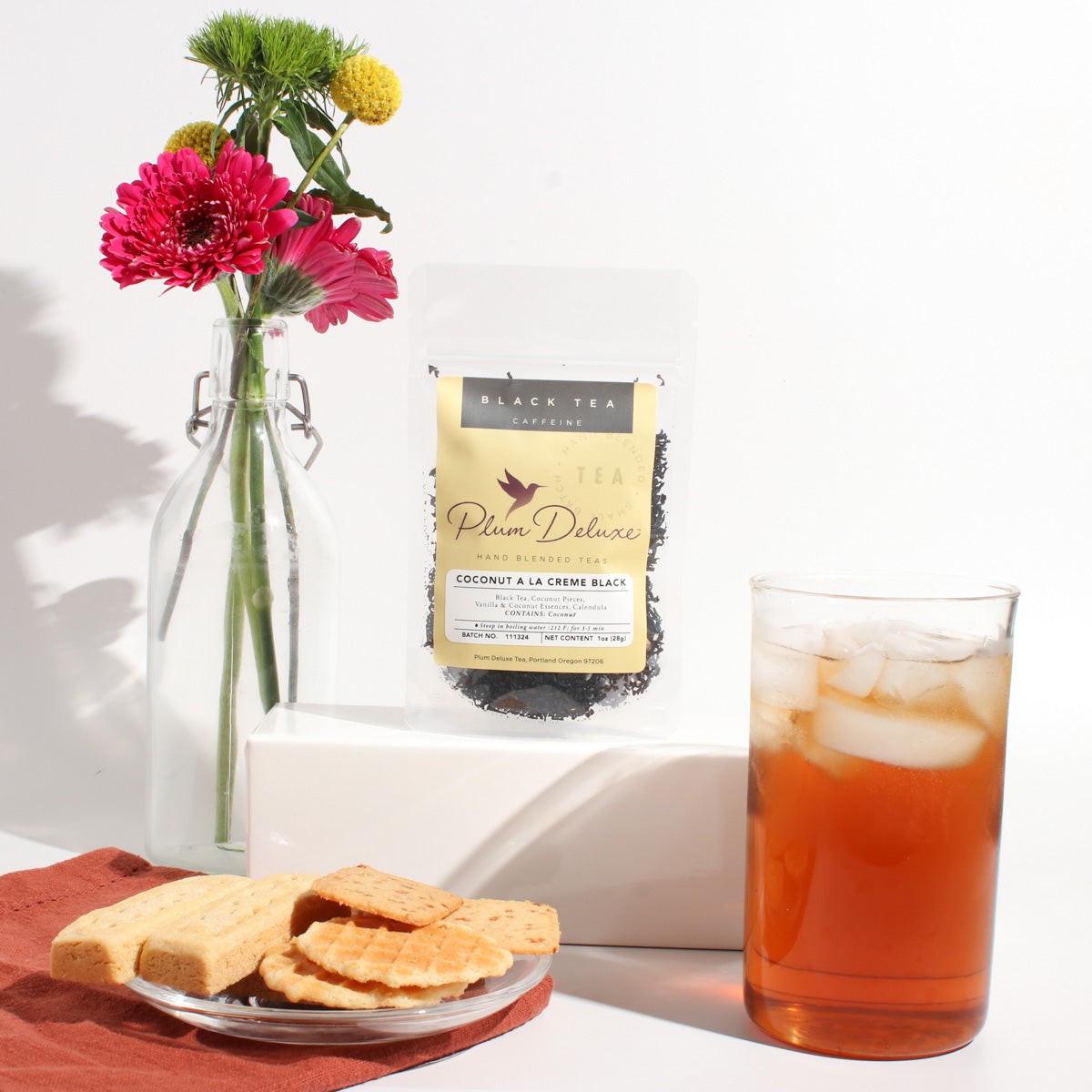 Plum Deluxe Coconut A La Creme Black Tea in a lifestyle setting, showcasing the tea packaging and ingredients.