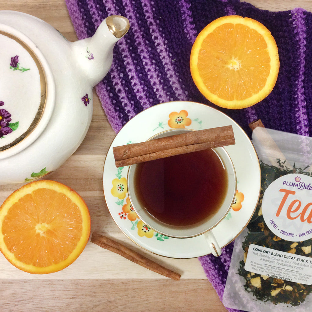 Plum Deluxe Comfort Blend Decaf Black Tea (Orange - Cinnamon) in a square package, showcasing tea blend and ingredients.