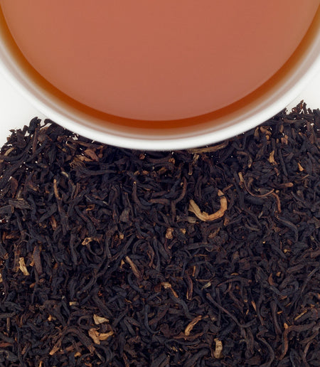 Harney & Sons Decaf Mango tea in a cup, showcasing a vibrant infusion with fruity notes and aromatic steam.