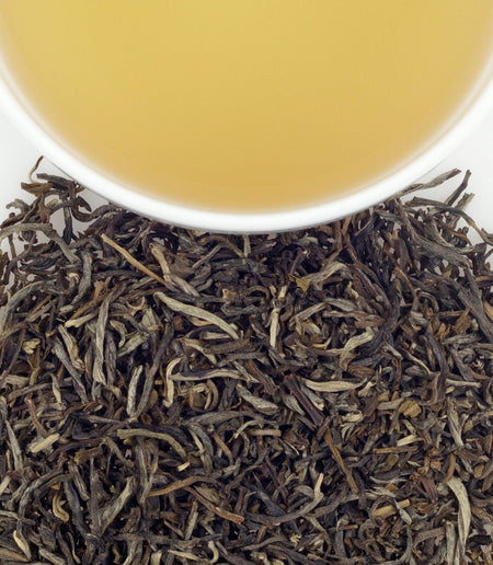 Harney & Sons Jasmine Tea in a cup, showcasing the tea's gentle brown hue and aromatic infusion with jasmine flowers.