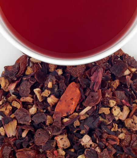 Harney & Sons Mango Fruit Tea in a cup, showcasing the ruby red infusion with dried mango and fruit pieces.