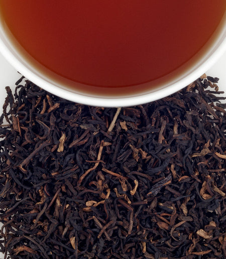 Cup of Harney & Sons Midsummer's Peach (Decaf) tea, featuring a warm peach color, served in a tea cup.