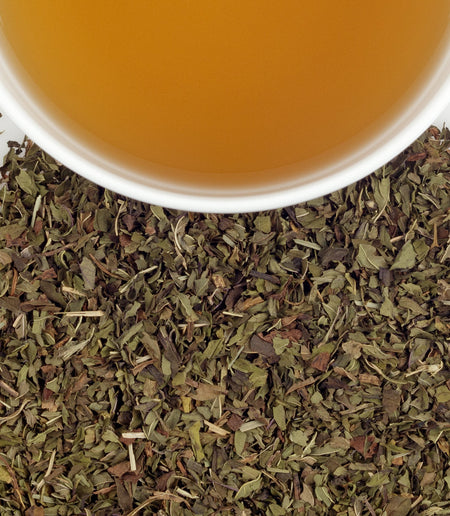 Cup of Harney & Sons Peppermint Herbal tea showcasing vibrant peppermint leaves in a steaming cup