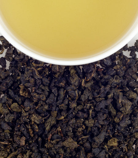Harney & Sons Pomegranate Oolong tea in a cup, showcasing its rich color and inviting texture, with pomegranate notes visible.