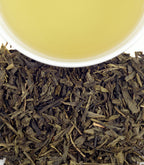 Harney & Sons Tropical Green, Tin of 20 Sachets, displayed in a cup, showcasing the tea's vibrant color and packaging.