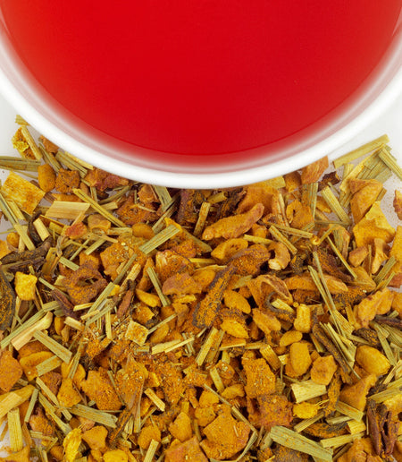 Harney & Sons Organic Ginger Turmeric tea in a cup, showcasing its ruby color and herbal ingredients like ginger and turmeric.