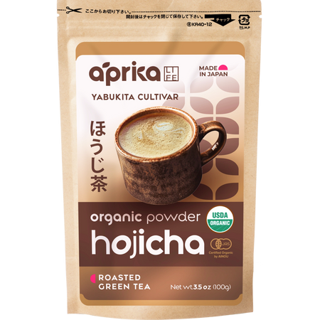 Aprika Life Hojicha Green Tea Powder in a bowl, showcasing its earthy color and texture, with a focus on natural ingredients.