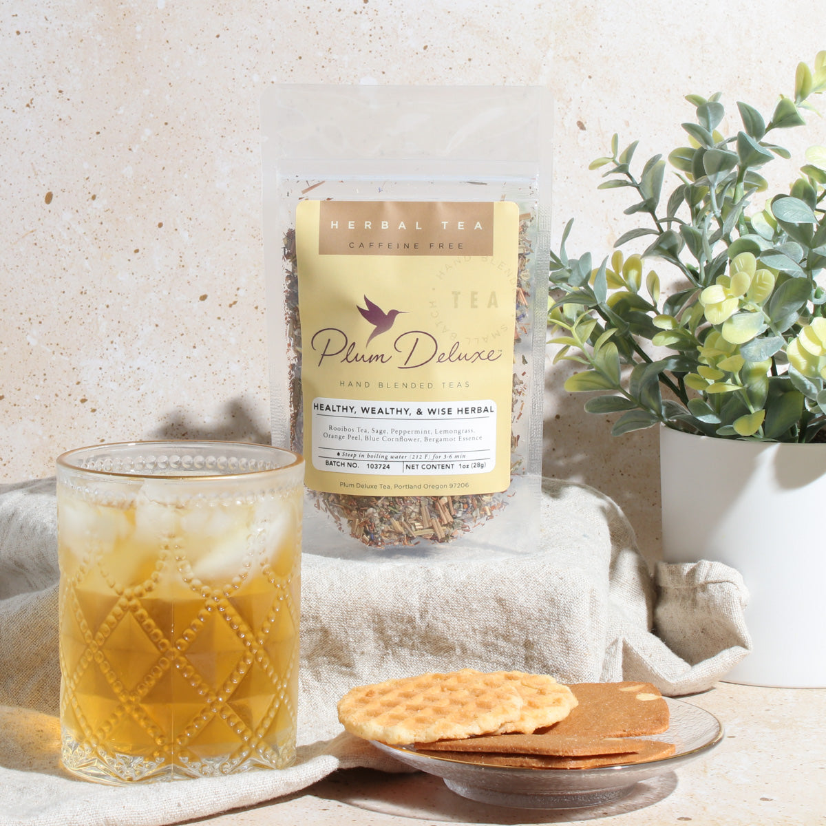 Plum Deluxe Healthy, Wealthy, & Wise Herbal Tea with bergamot, sage, lemongrass, and mint in a lifestyle setting.